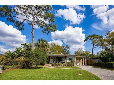 Charming single-story home featuring a well-manicured lawn, mature trees, and a cozy covered porch at 3519 Backspin Ln, Orlando, FL 32804