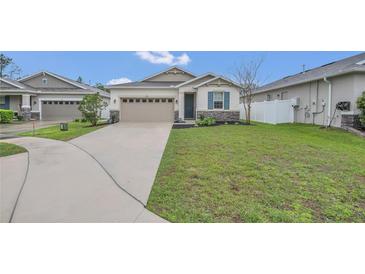Charming one-story home with a well-manicured lawn and a two-car garage at 4009 Swan Goose Ct, Okahumpka, FL 34762