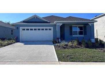 Charming blue one-story home with well-manicured lawn and a two car garage at 487 Taylor Groves Dr, Lake Wales, FL 33898