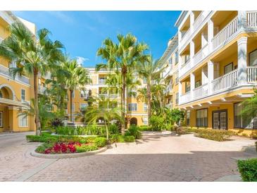 Beautiful apartment building exterior with a courtyard featuring tropical landscaping and a fountain at 860 N Orange Ave # 444, Orlando, FL 32801
