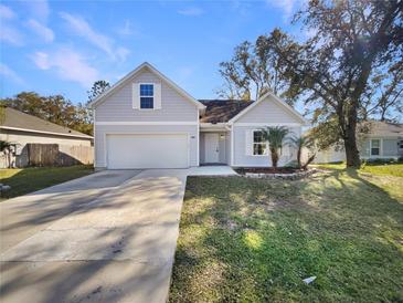 Charming home featuring a two-car garage, neat landscaping, and a welcoming front entrance at 1004 Puget Ln, Kissimmee, FL 34759