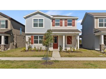 Two-story home with red shutters and a well-manicured lawn showcases charming curb appeal at 11356 Sunsail Ave, Orlando, FL 32832