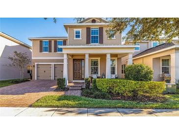 Charming two-story home with a landscaped yard, covered porch, and two-car garage at 15496 Sweet Orange Ave, Winter Garden, FL 34787