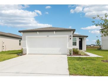 Charming home features a two-car garage, well-manicured lawn, and modern design at 2511 Linda Knoll Ln, Bartow, FL 33830