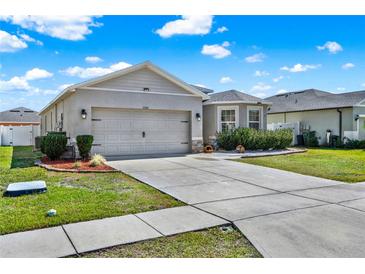 Attractive single-story home with a spacious driveway, lush lawn, and well-maintained landscaping at 3086 Brenton Manor Loop, Winter Haven, FL 33881