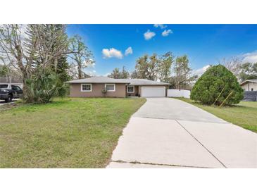 Charming single-story home featuring a long driveway and attached two-car garage at 5410 S Pine Hill Cir, Orlando, FL 32808