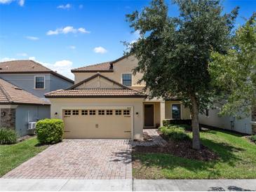 Charming two-story home with tile roof, brick driveway and attached two car garage at 9023 Shadow Mountain St, Davenport, FL 33896