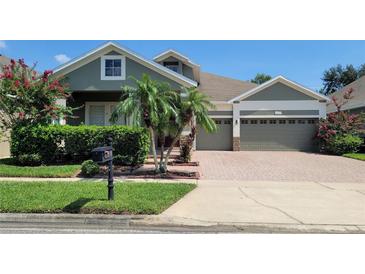 Charming home featuring a well-manicured lawn, brick driveway, and a two-car garage at 13413 Zori Ln, Windermere, FL 34786
