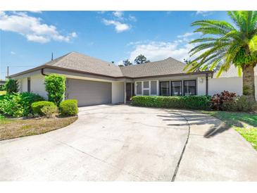 Charming single-story home featuring a spacious driveway, lush landscaping, and an attached two-car garage at 1489 Magellan Cir # 603, Orlando, FL 32818
