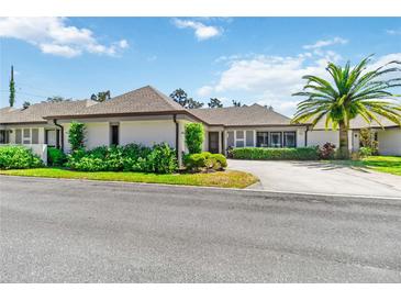Beautiful single-story home showcasing lush landscaping, a palm tree, and an expansive driveway at 1489 Magellan Cir # 603, Orlando, FL 32818