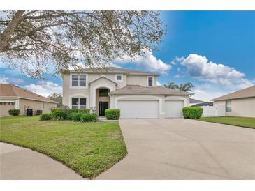Charming two-story home featuring a three-car garage, arched entry, and well-manicured landscaping at 1827 Lindzlu St, Winter Garden, FL 34787