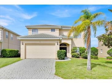 Beautiful two-story home featuring a large two car garage and a mature palm tree in front at 210 Vista Loop, Davenport, FL 33897