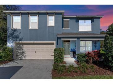 Charming two-story home featuring a 2-car garage, beautifully landscaped front yard, and inviting front porch at 219 Meghan Cir, Deland, FL 32724