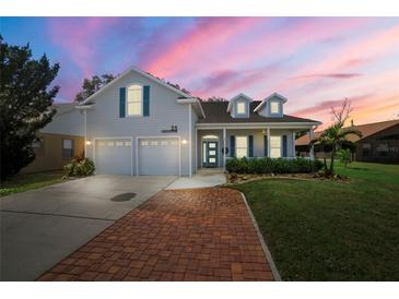 Charming two-story home with a brick driveway, manicured lawn, and a welcoming front porch at 25 Lakeshore Blvd, St Cloud, FL 34769