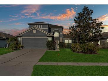Charming two-story home featuring manicured landscaping, an attached two-car garage, and elegant architectural details at 2933 White Cedar Cir, Kissimmee, FL 34741