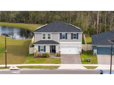 Beautiful two-story home with a well-manicured lawn and a brick paver driveway and two-car garage at 2984 Sanctuary Dr, Clermont, FL 34714