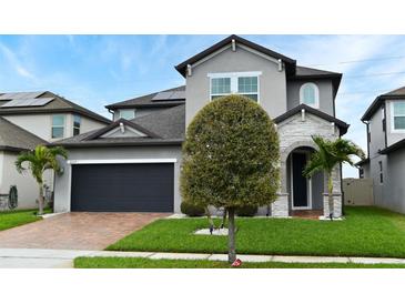 Charming two-story home featuring a brick driveway, two-car garage and lush landscaping at 3237 Palatka St, Orlando, FL 32824