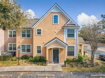 Charming two-story townhome featuring a welcoming front porch and beautiful landscaping at 3403 Greenwich Village Blvd # 104, Orlando, FL 32835