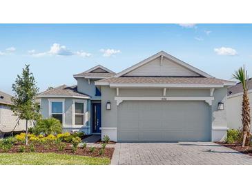 Charming single-story home featuring a two-car garage, paver driveway, manicured landscaping, and a neutral color palette at 4198 Barbuda Ln, Kissimmee, FL 34758