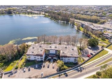 Stunning aerial view of lakeside apartments, showcasing the building, surrounding trees, and ample parking at 4575 S Texas Ave # 205, Orlando, FL 32839