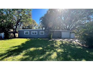 Charming single-story home featuring a lush green lawn and mature trees, offering a serene and inviting curb appeal at 5200 Brosche Rd, Orlando, FL 32807