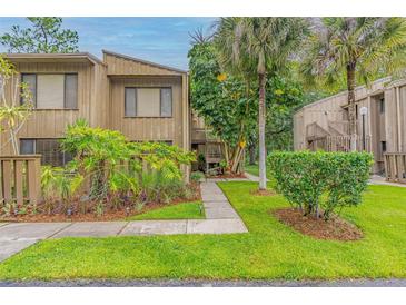 Inviting condo featuring a quaint walkway, lush landscaping, and a charming wood facade at 5337 Indian Creek Dr # C-4-1, Orlando, FL 32811
