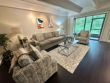 Inviting living room featuring a comfortable sofa, stylish armchairs, and a sliding glass door to a balcony at 5337 Indian Creek Dr # C-4-1, Orlando, FL 32811
