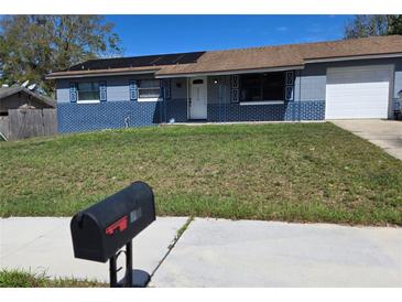 Charming single-story home with a well-maintained lawn and solar panels at 7813 Arabian Pl, Orlando, FL 32818