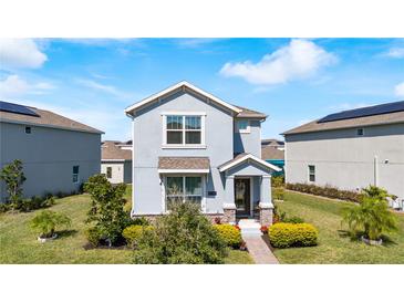 Charming two-story home with manicured landscaping and inviting front porch at 9747 Petition Way, Orlando, FL 32832