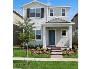 Charming two-story home with a blue front door, tidy landscaping, and freshly cut green grass at 15543 Gentle Rain Dr # 197, Winter Garden, FL 34787