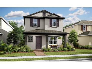 Charming two-story home featuring neutral stucco, a covered porch, and well-manicured landscaping at 15585 Gentle Rain Dr # 191, Winter Garden, FL 34787