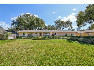 Charming single-story home with a well-manicured lawn and mature trees providing shade at 215 Forrest Dr, Sanford, FL 32773