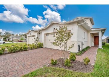 Charming villa featuring a brick driveway and attached garage with a beautifully landscaped front yard at 2312 Datura Loop, St Cloud, FL 34772