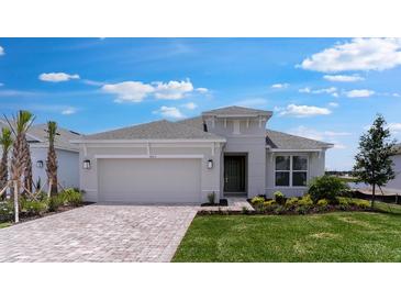 Beautiful single-story home featuring manicured lawn, brick driveway, and an attached two-car garage at 4203 Barbuda Ln, Kissimmee, FL 34758