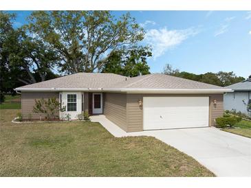 Charming single-story home with a well-manicured lawn, two car garage and mature trees at 6133 Seagull Ln, Lakeland, FL 33809