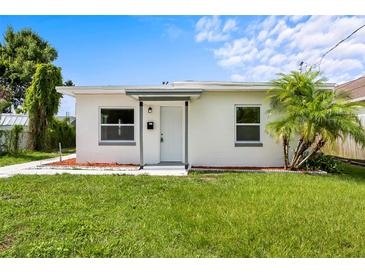 Charming single-story home with a well-manicured lawn and freshly painted white exterior at 859 Neuse Ave, Orlando, FL 32804