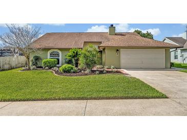 Charming single-story home with a well-manicured lawn and verdant landscaping at 1002 Ohanlon Ct, Oviedo, FL 32765