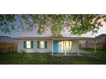 Charming single-story home featuring a cozy front porch and vibrant blue door and shutters at 1315 Overdale St, Orlando, FL 32825