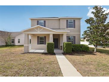 Charming two-story home with a covered front porch and well-maintained landscaping at 1893 Rafton Rd, Apopka, FL 32703