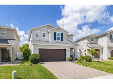 Charming two-story home with a two-car garage, brick driveway, and beautifully landscaped front yard at 2817 Noble Crow Dr, Kissimmee, FL 34744