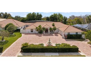 Beautiful home with red brick driveway, well-manicured landscaping, and a charming water fountain at 5950 Masters Blvd, Orlando, FL 32819