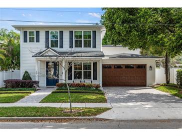 Charming two-story home with a well-manicured lawn, brick pathway, and a two car garage at 900 Golfview St, Orlando, FL 32804
