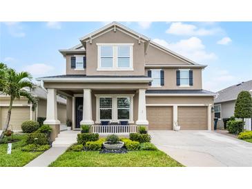 Charming two-story home with landscaped yard and a two-car garage under a bright blue sky at 10078 Greenshire Way, Orlando, FL 32827