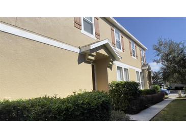 Charming two-story home with a well-manicured lawn, tan siding, and brown trim accents at 10711 Yellow Tiger Lily Dr # S, Orlando, FL 32832
