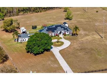 Expansive property with a custom home featuring solar panels and a circular driveway at 17117 Heartwood Loop, Winter Garden, FL 34787