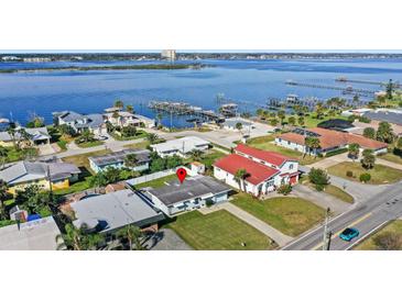 An aerial view of single-story home showcasing its waterfront location and neighborhood at 3226 S Peninsula Dr, Daytona Beach Shores, FL 32118