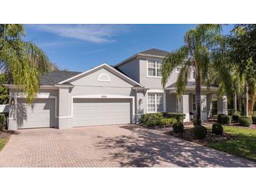 Charming two-story home with manicured landscaping, paver driveway, and attached two car garage at 5006 Legacy Oaks Dr, Orlando, FL 32839