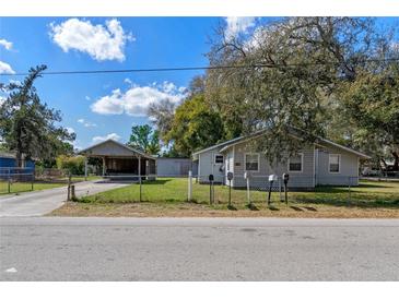 Charming single-story home with well-maintained lawn, a carport, and multiple mailboxes at 519 Pearl St, Mascotte, FL 34753