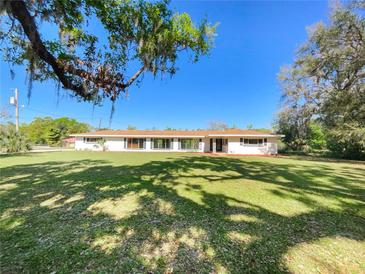 Charming single-story home featuring a spacious front yard with mature trees and well-maintained landscaping at 915 Oak Ln, Lakeland, FL 33811