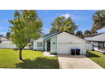 Charming single-story home with a well-maintained lawn, mature trees, and a two-car garage at 11336 Bingham Ct, Orlando, FL 32837